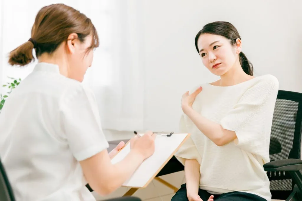 肩の不調を相談中の女性