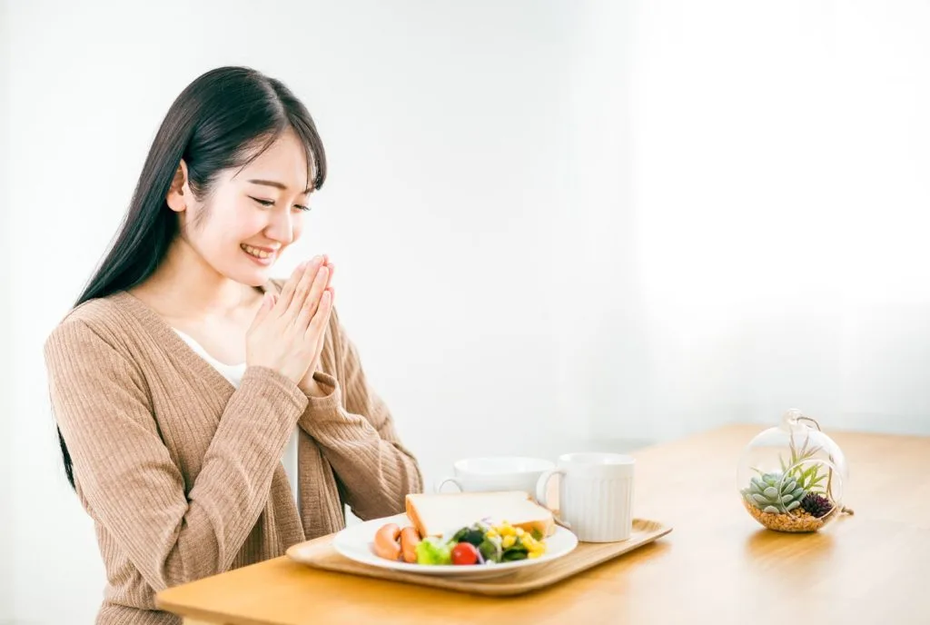 いただきますポーズをする女性