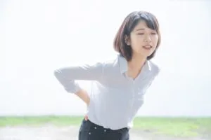 腰を抑える女性