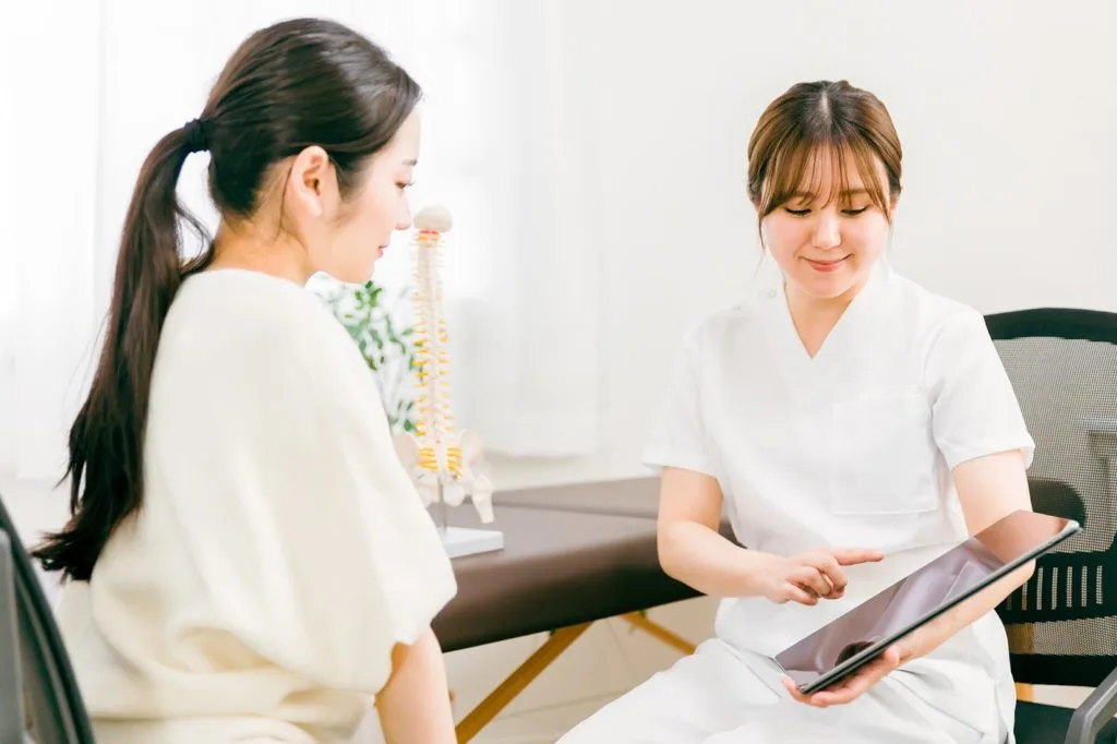 問診をする女性整体師