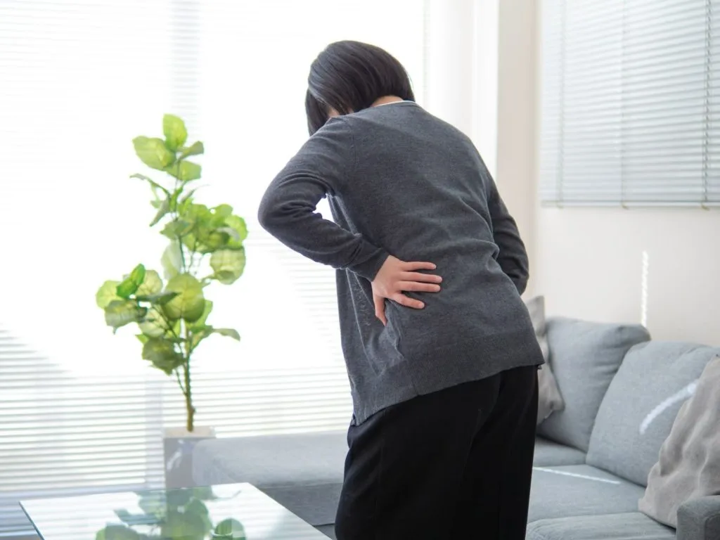 腰を押さえる女性