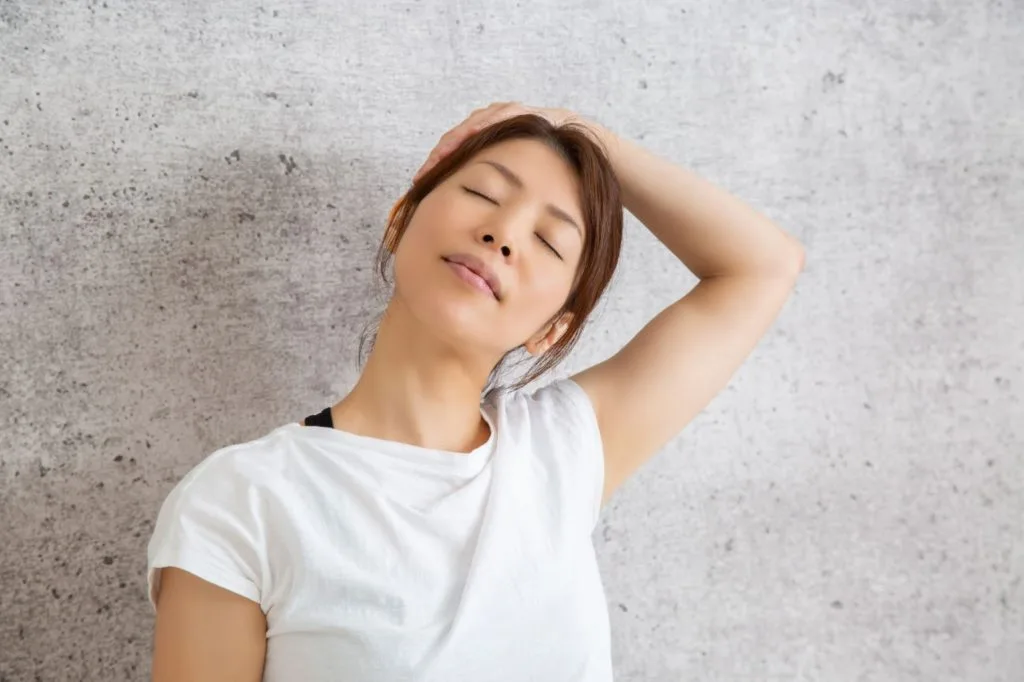 左手を使って首を横に伸ばしている女性