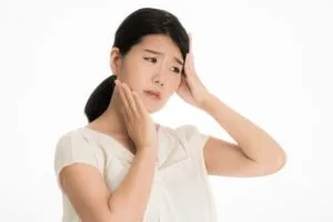 首の不調を感じている女性