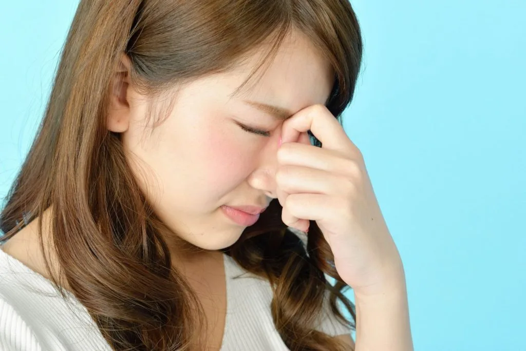 目頭を押さえる女性