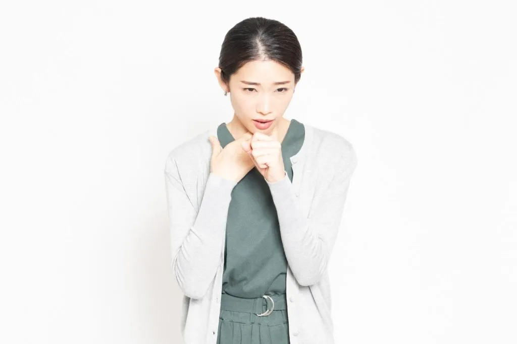 くしゃみを我慢女性