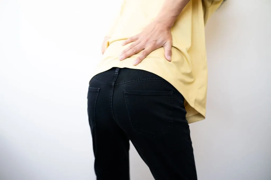 右手を腰に当てて前かがみになっている様子
