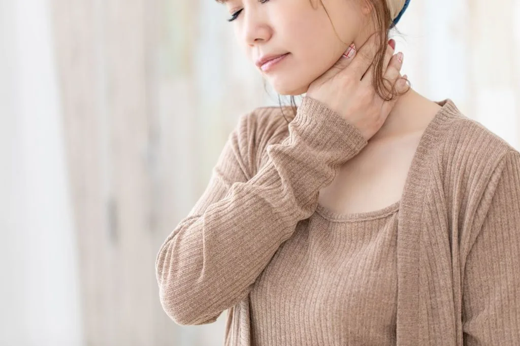 首を押さえる女性