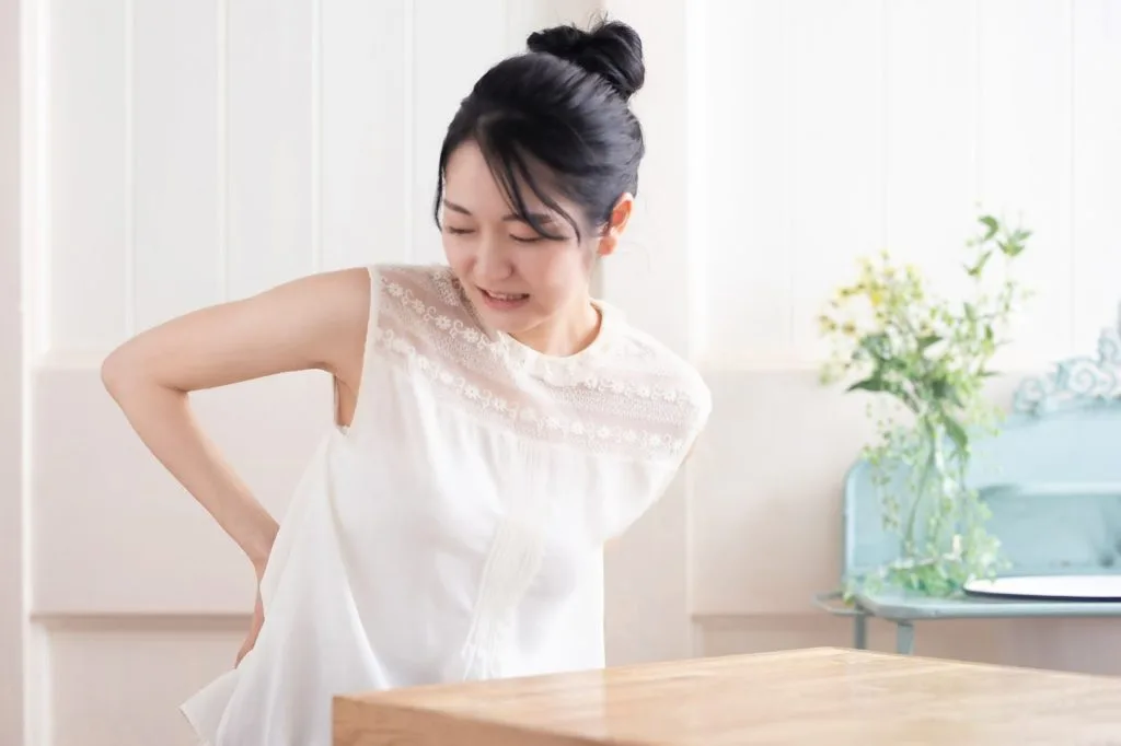 腰に手を当てる女性