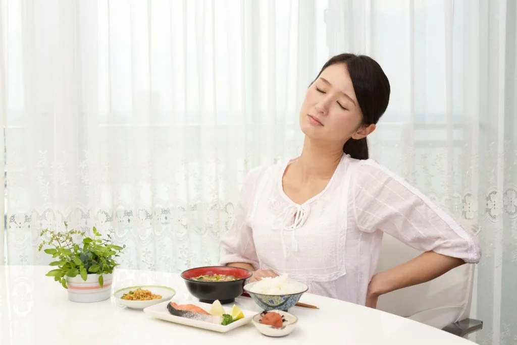 腰の辺りを気にする女性