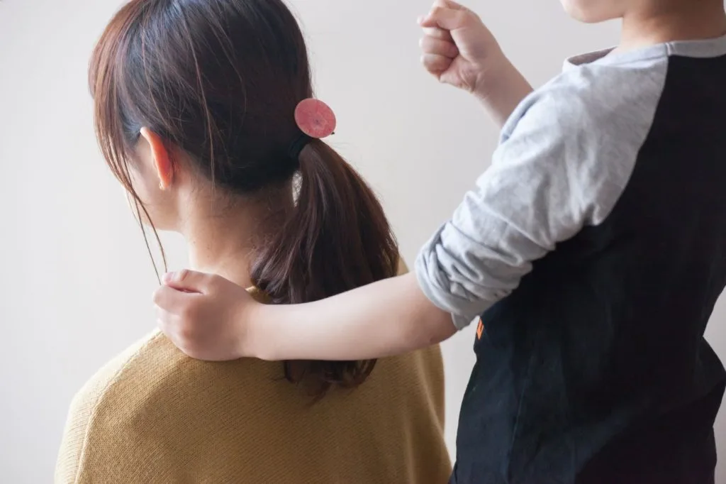 肩をたたいてもらっている女性