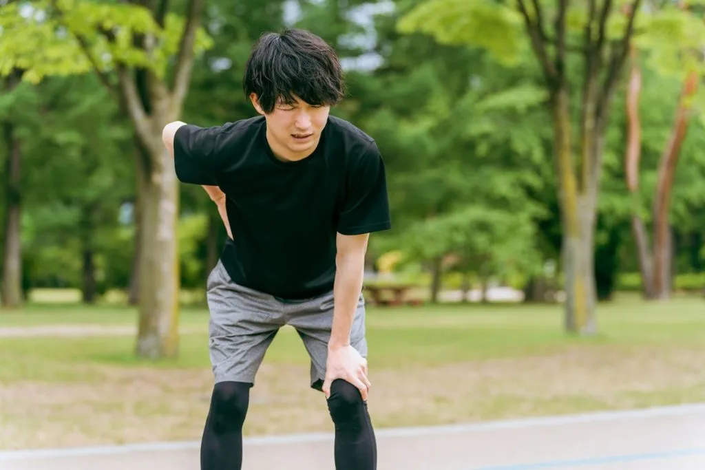 腰の痛みを気にする男性