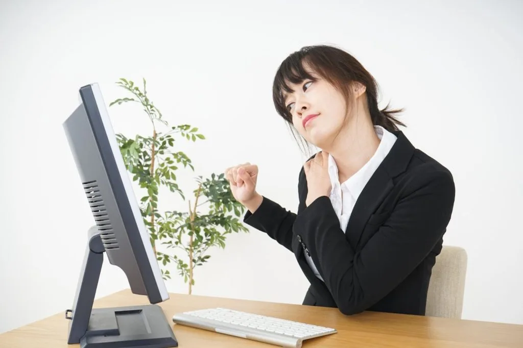 仕事中肩を回す女性