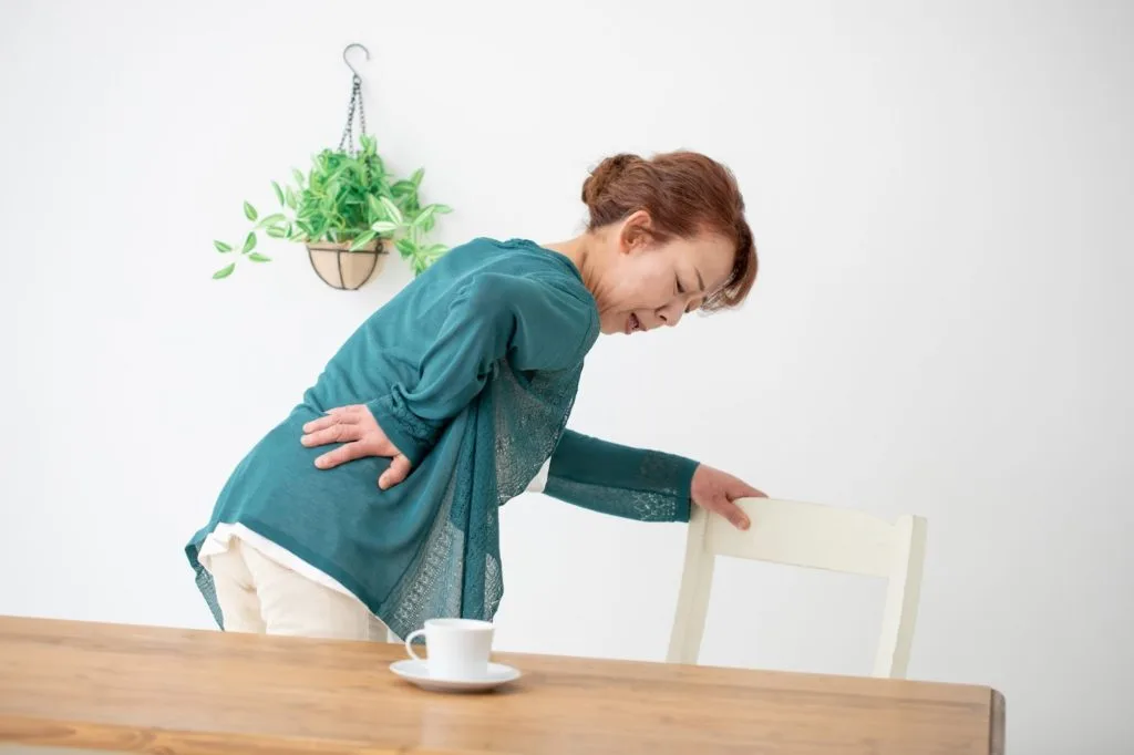 腰の辺りを気にする女性