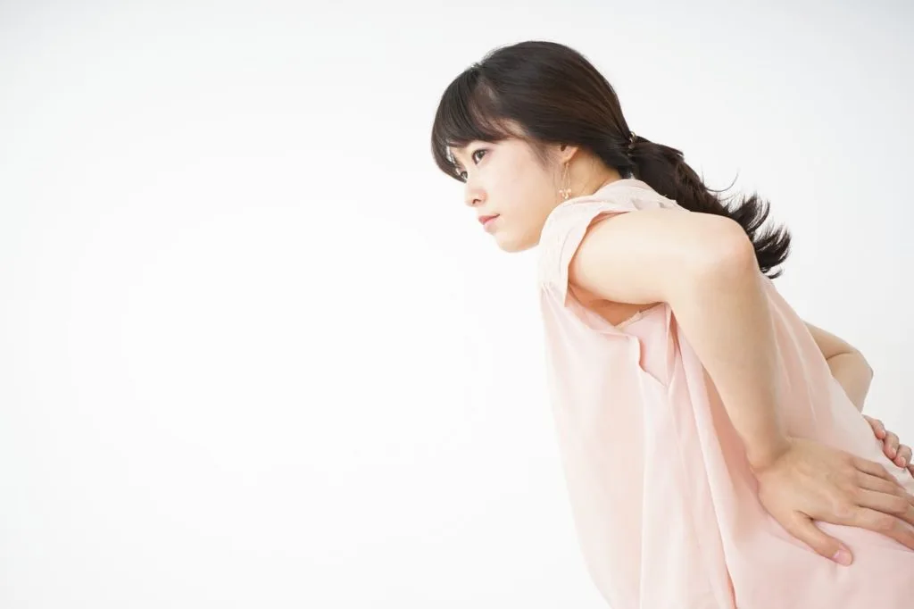 腰の辺りを気にする女性