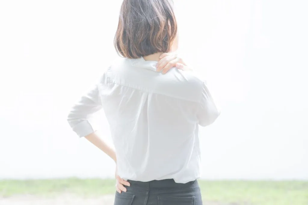 肩を抑える女性