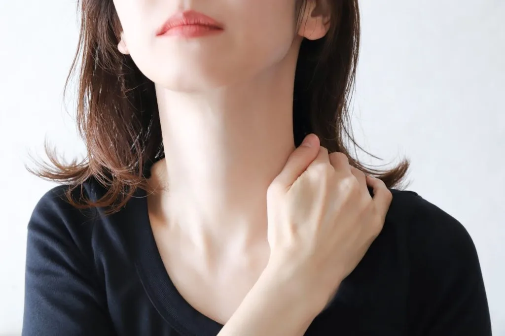 肩に手をあてる女性