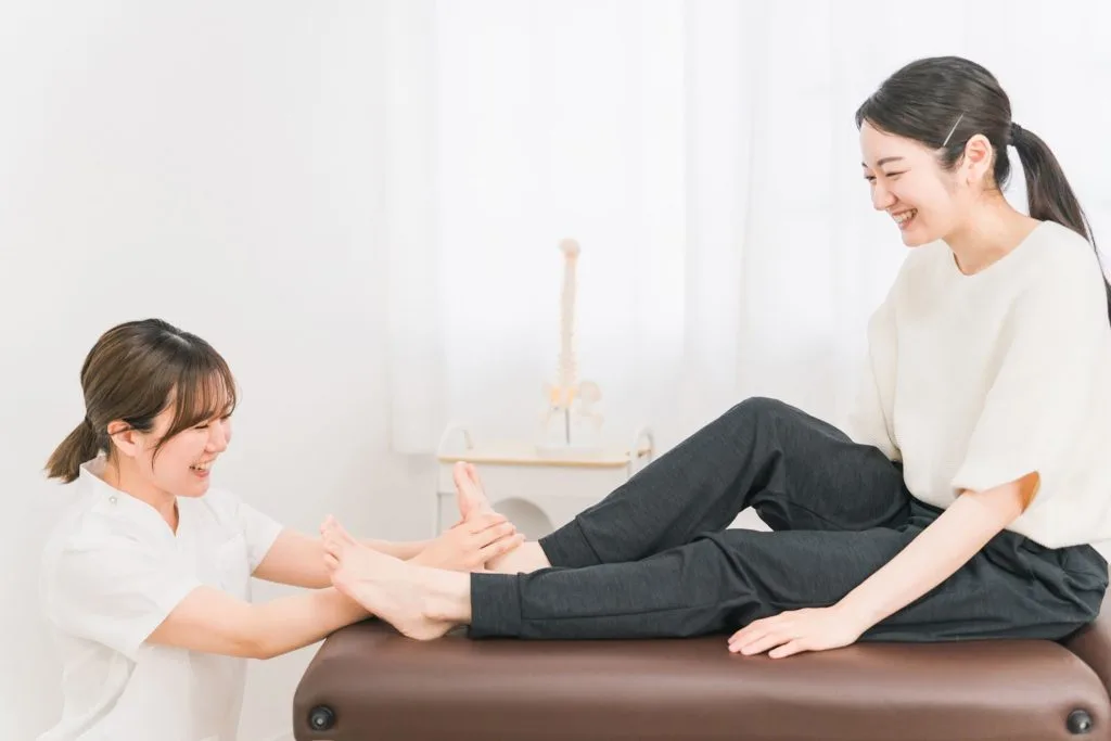 足の裏を整体師に診てもらう女性
