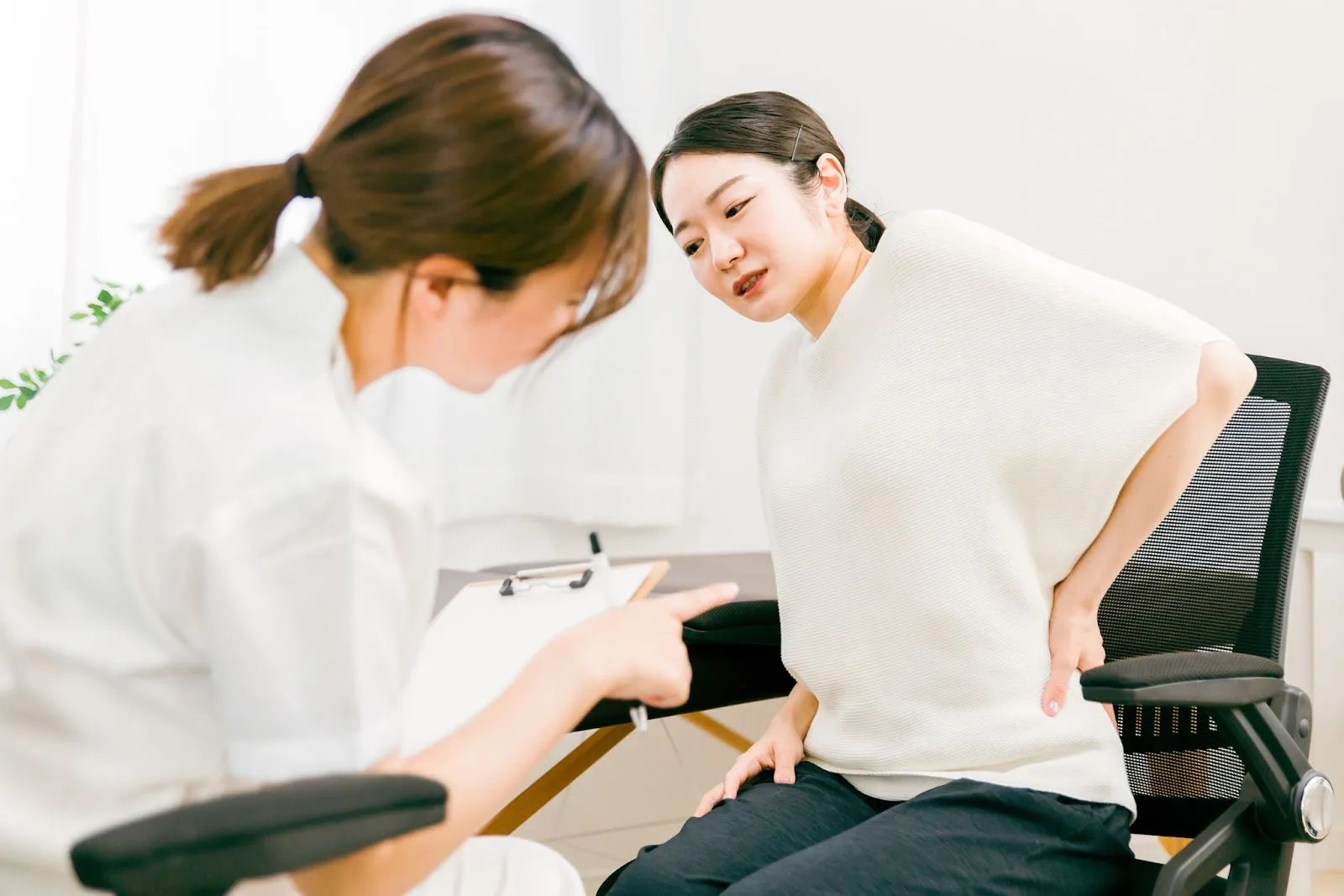 腰の不調を訴える女性
